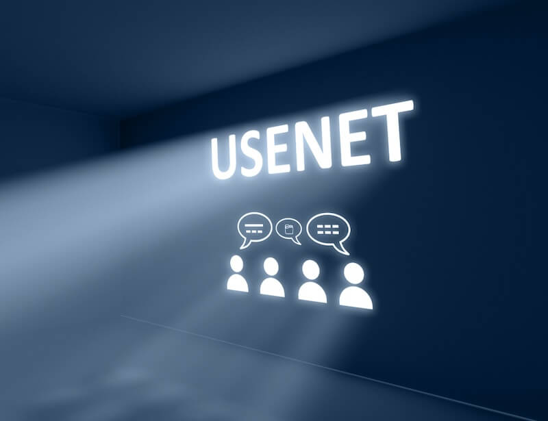 A movie theater that is projecting the word “Usenet” on the screen along with the silhouettes of people talking to one another.